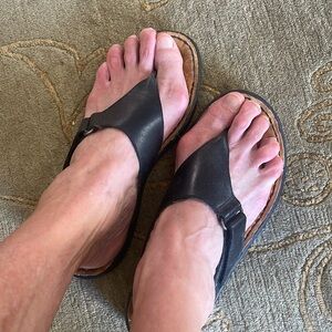 Minnetonka black leather sandals with adjustable velcro strap and buckle.